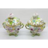 A pair of continental florally encrusted lidded pots, 14cm, some petals a/f