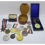 A collection of medals and badges, a stick pin and a fob watch