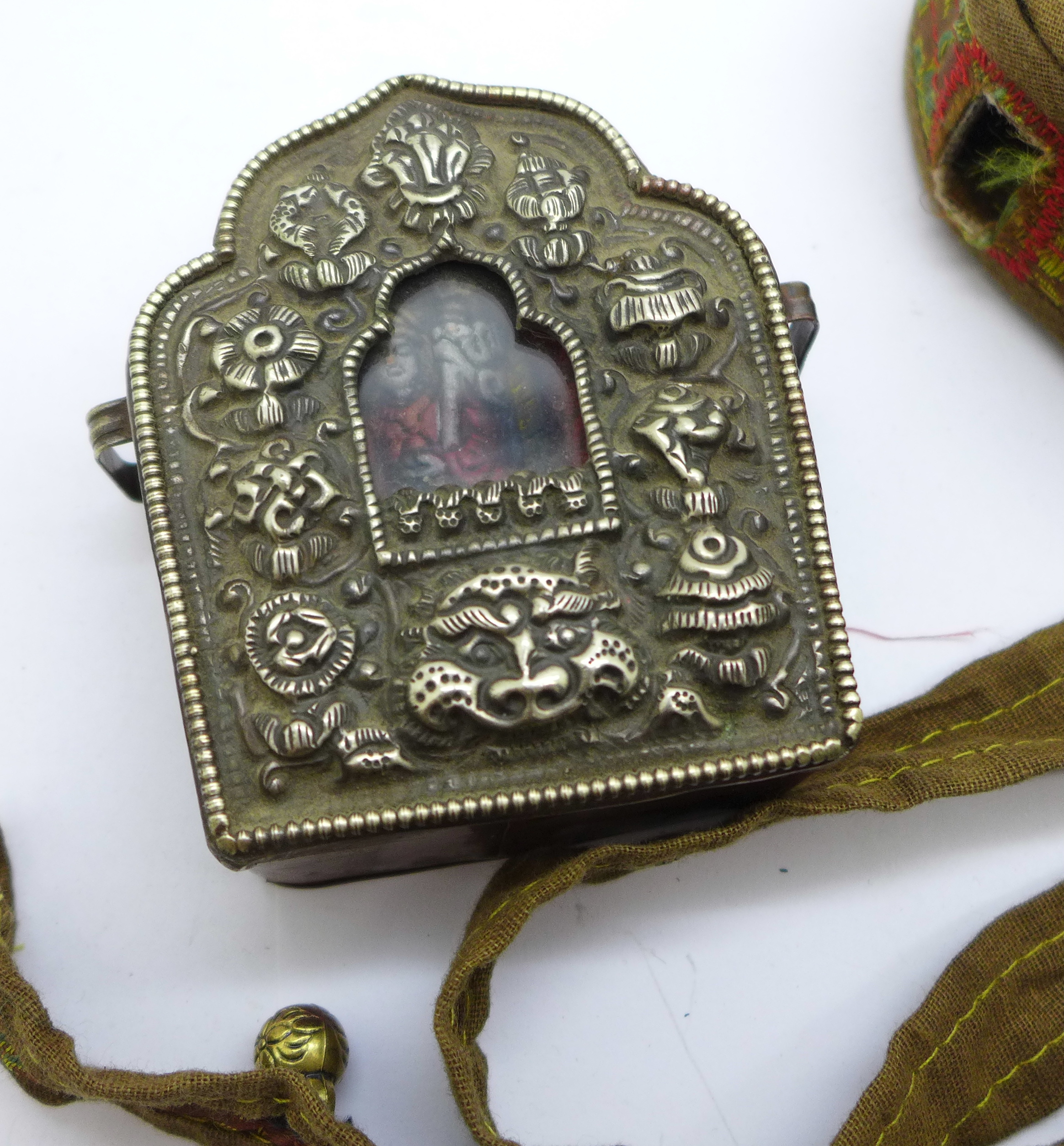A Tibetan Ghau prayer box in copper and white metal within a canvas and needlework pouch - Image 2 of 4