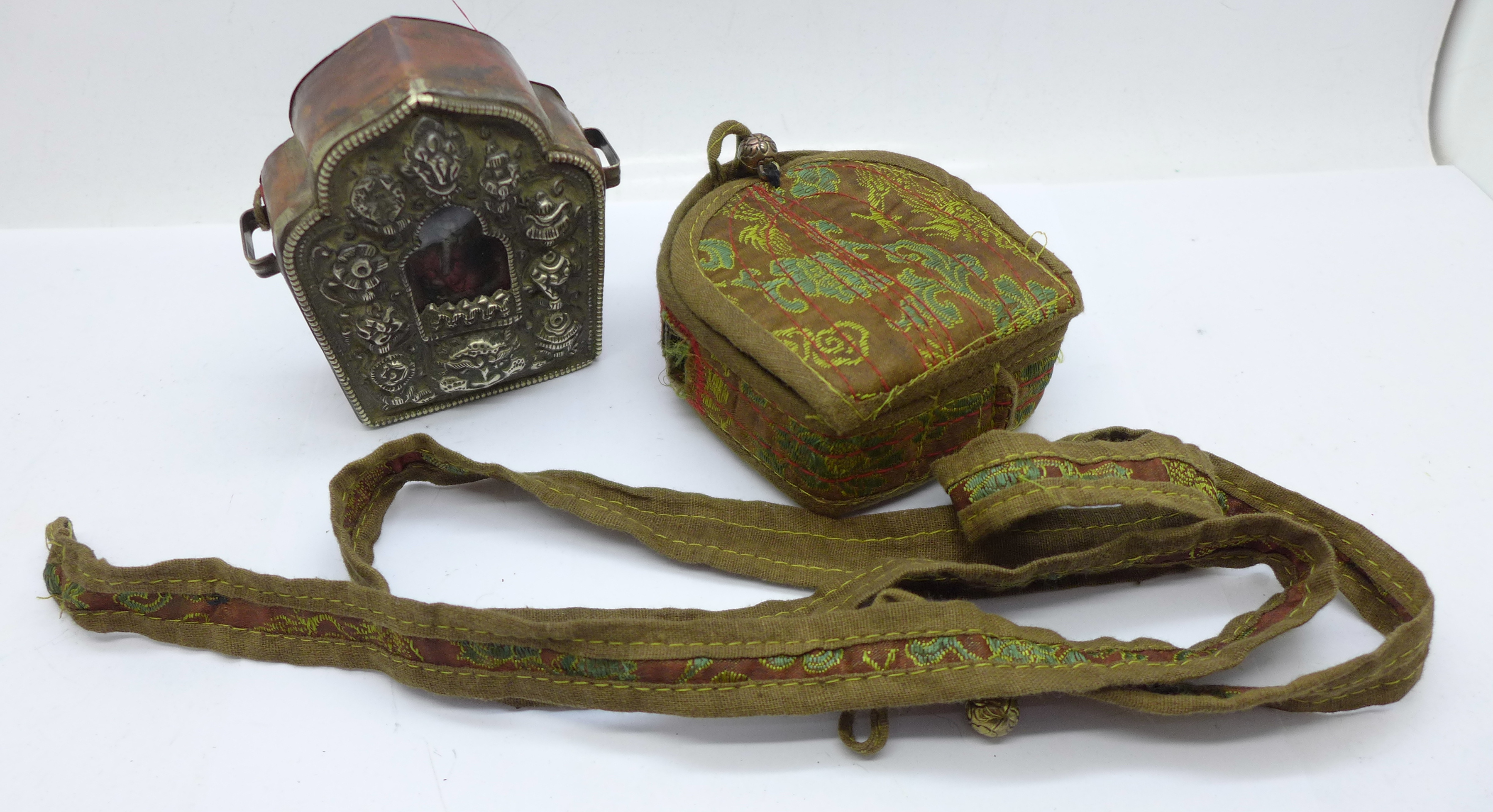 A Tibetan Ghau prayer box in copper and white metal within a canvas and needlework pouch