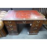 A Victorian oak and red leather topped desk