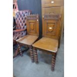 A pair of Victorian Gothic Revival oak hall chairs