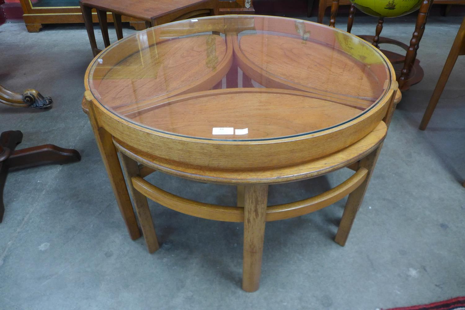 A Nathan teak and glass topped circular Trinity nest of tables