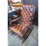 A mahogany and red leather rocking chair