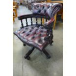 A mahogany and oxblood leather revolving desk chair