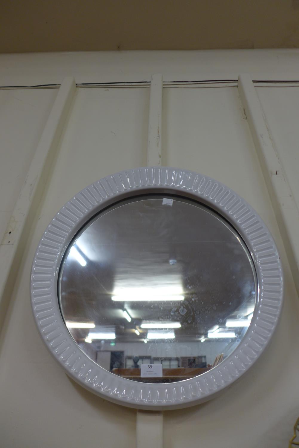 A mid 20th Century white ceramic framed circular mirror