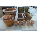 A pair of terracotta garden planters and other terracotta plant pots