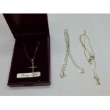 A silver cross pendant and chain and two other silver chains