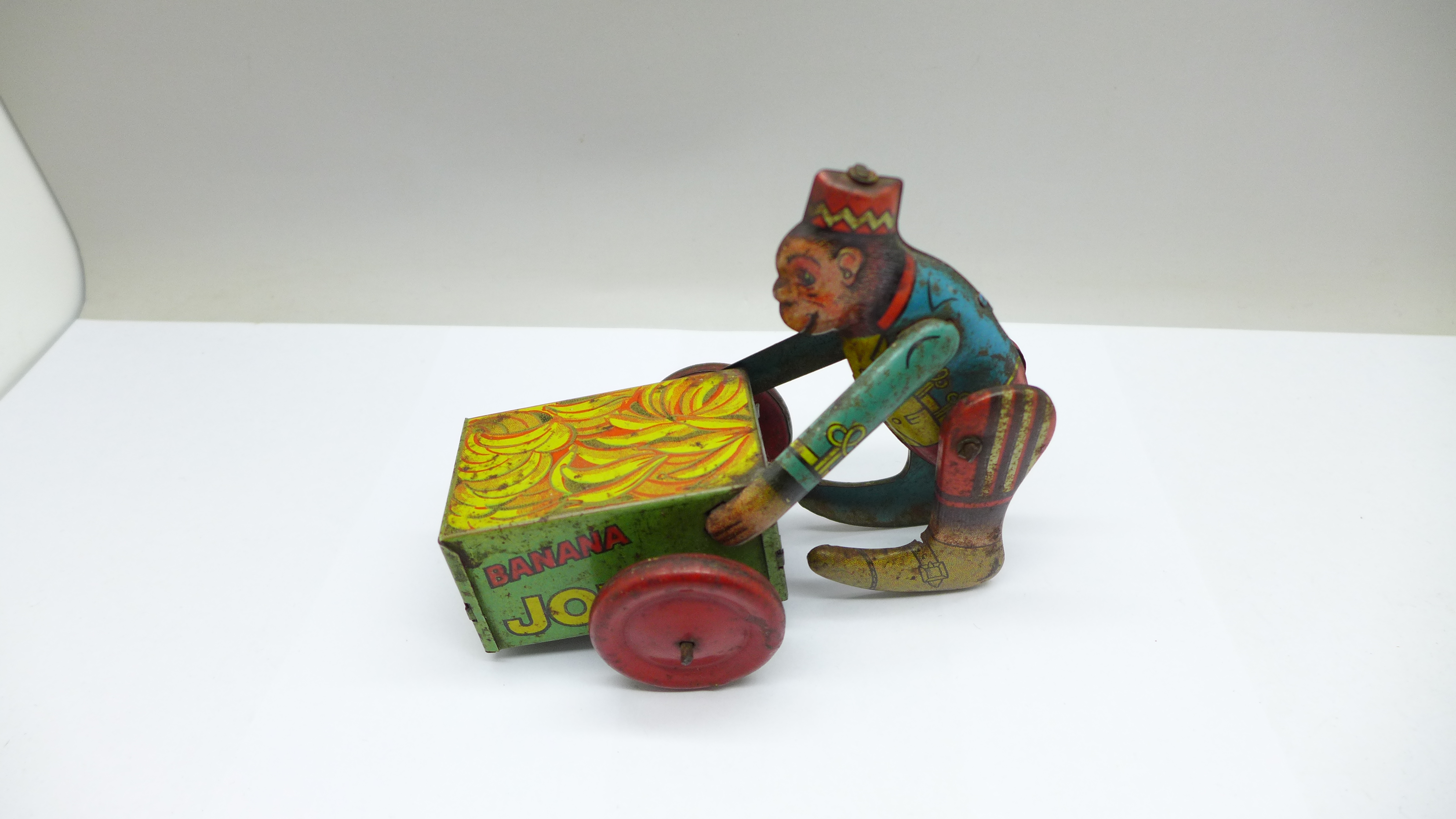 A vintage tin-plate clockwork toy monkey on a cart, marked made in England - Image 2 of 3