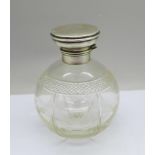 A silver topped globular glass bottle with stopper