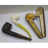 A cased pipe with amber mouthpiece, a Bakelite and clay pipe and a Dunhill briar pipe