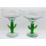 Two similar glass pedestal dishes, with green glass cactus stems and with pontil marks