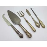 Five silver handled items including a cake slice and cheese knife