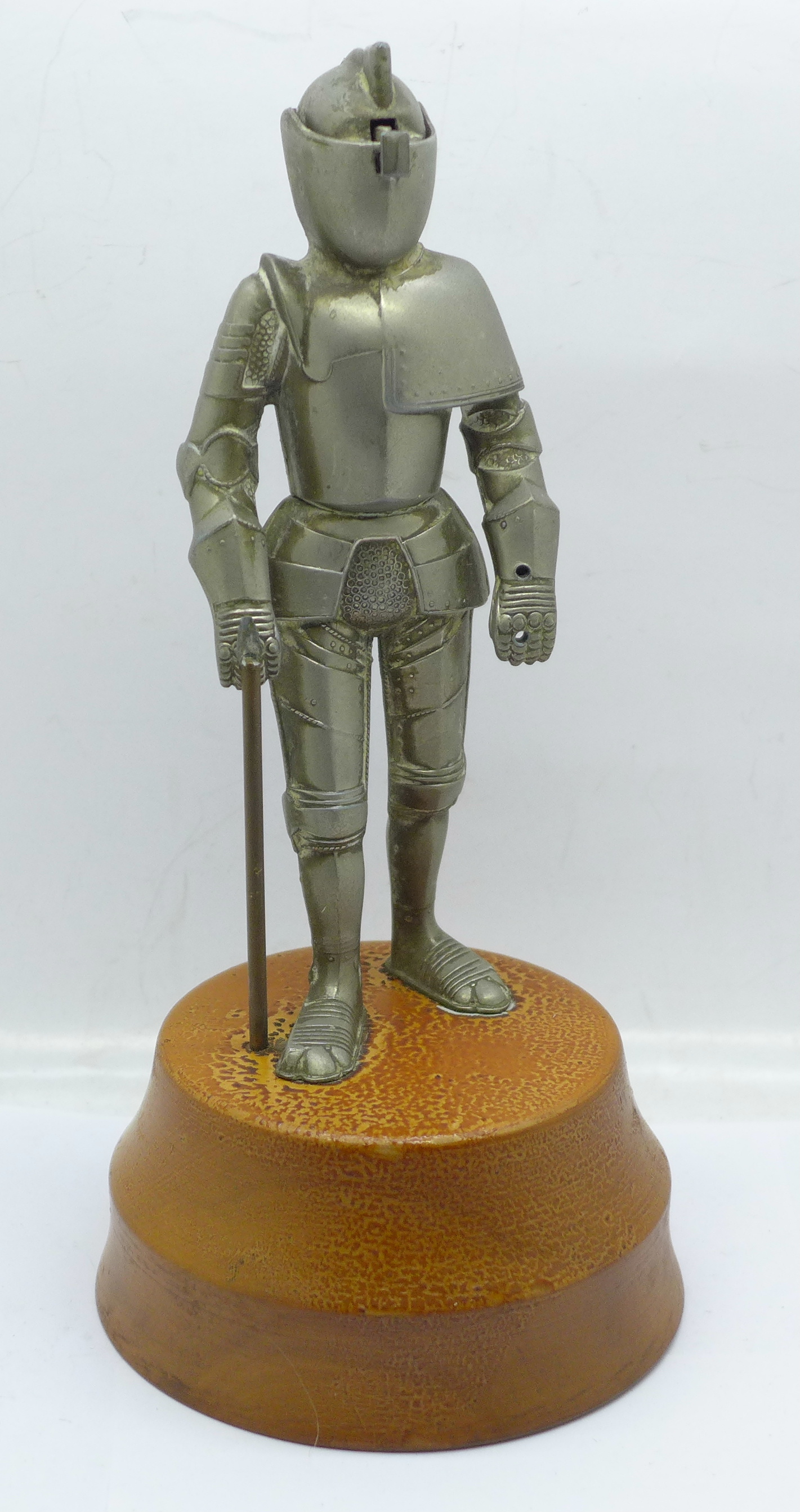 A metal Knight table lighter on a wooden base