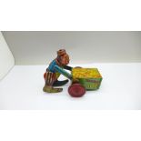 A vintage tin-plate clockwork toy monkey on a cart, marked made in England