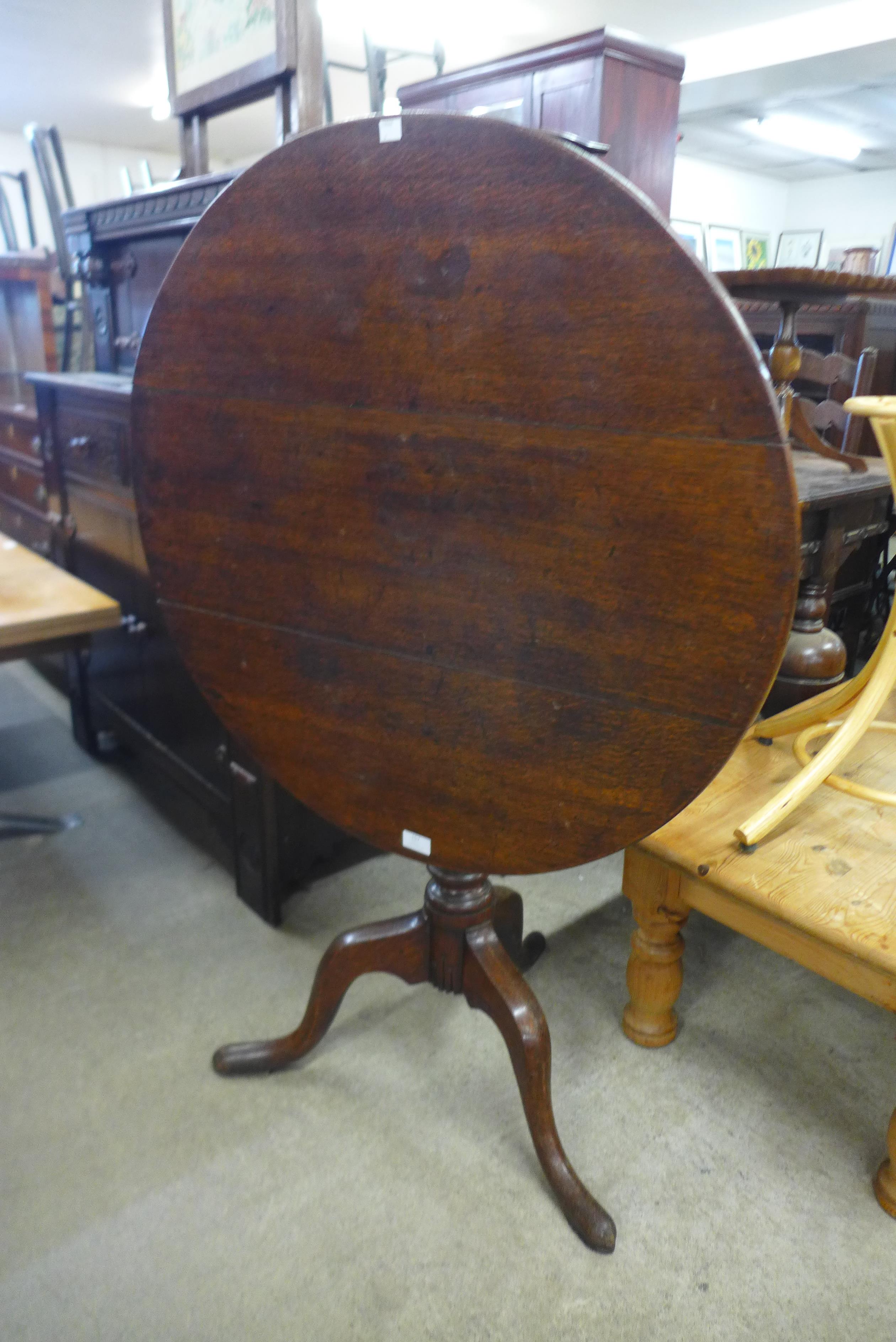 A Victorian oak circular tilt-top tea table