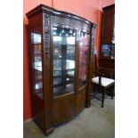 A Hepplewhite Revival carved mahogany two door bow front side cabinet