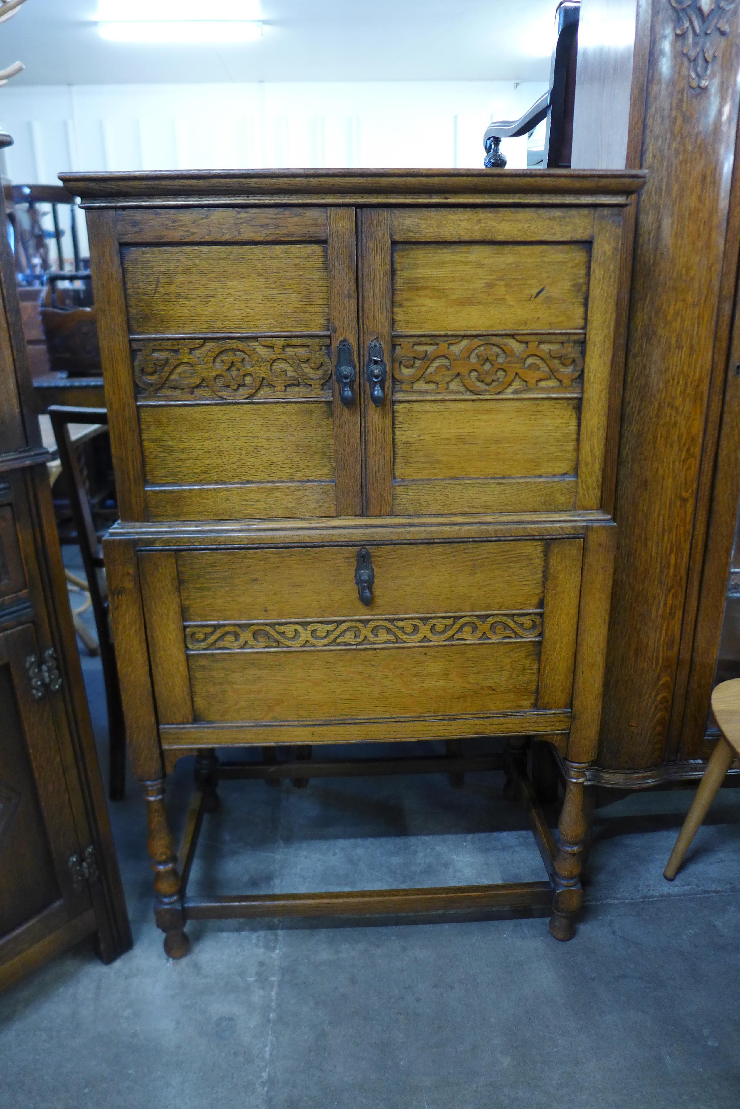 A carved oak three door side cabinet