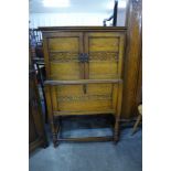 A carved oak three door side cabinet