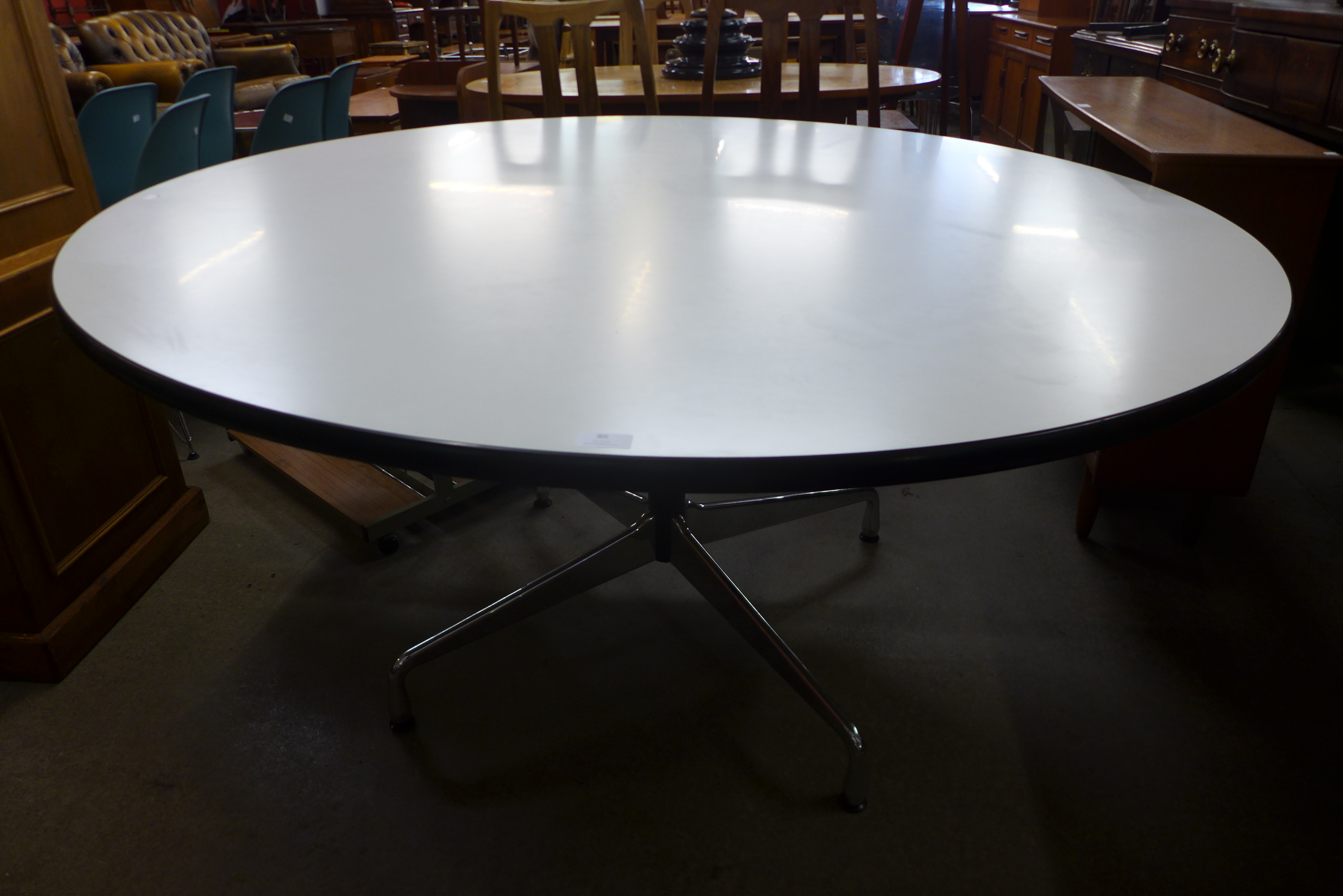 A Charles & Ray Eames chrome and white laminated circular Vitra dining table