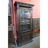 A French carved oak single door vitrine