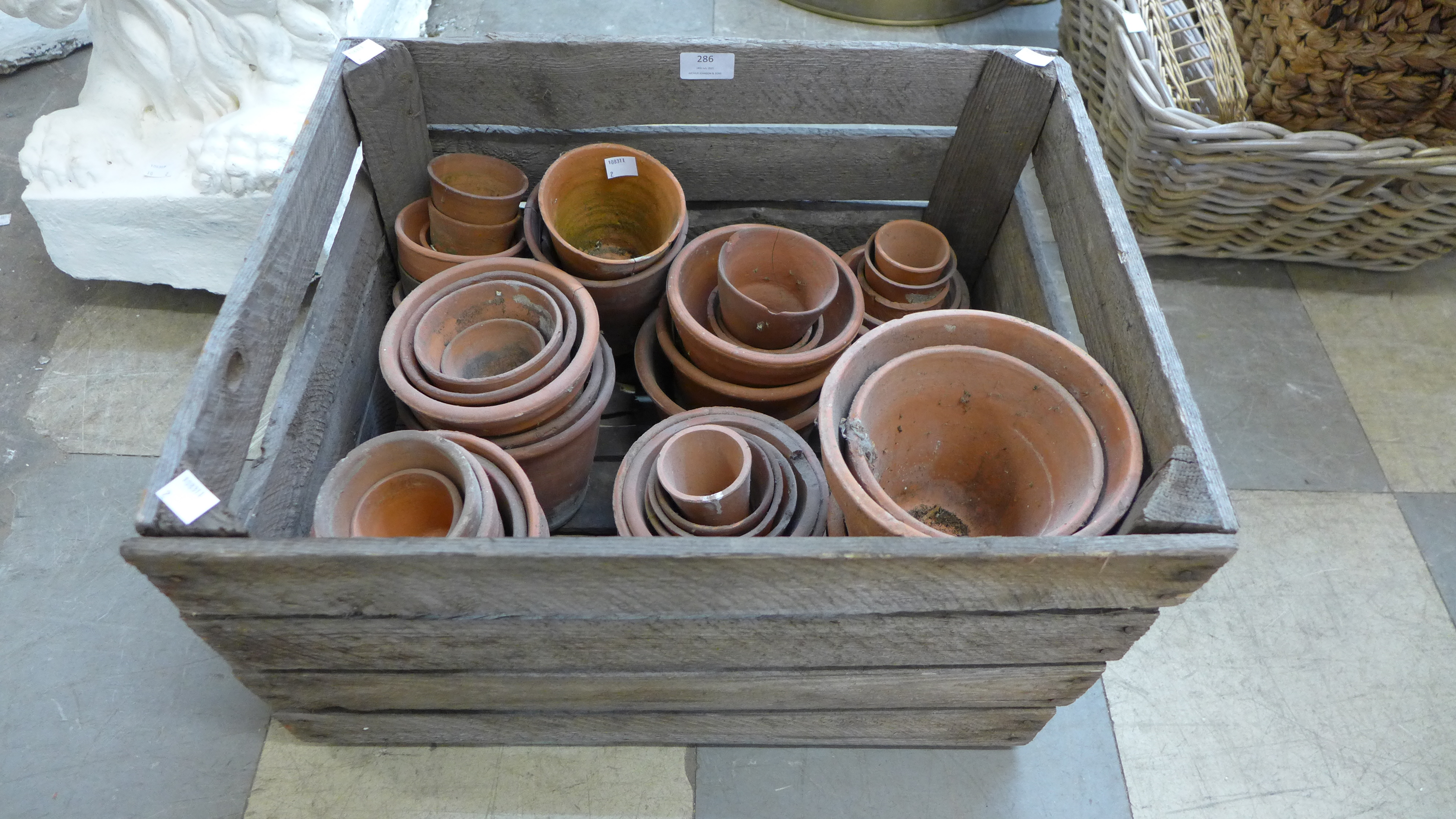 Assorted terracotta plant pots and a fruit crate