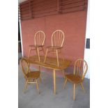 An Ercol Blonde elm and beech plank dining table and four Windsor chairs