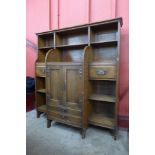 An Arts and Crafts oak open breakfront bookcase