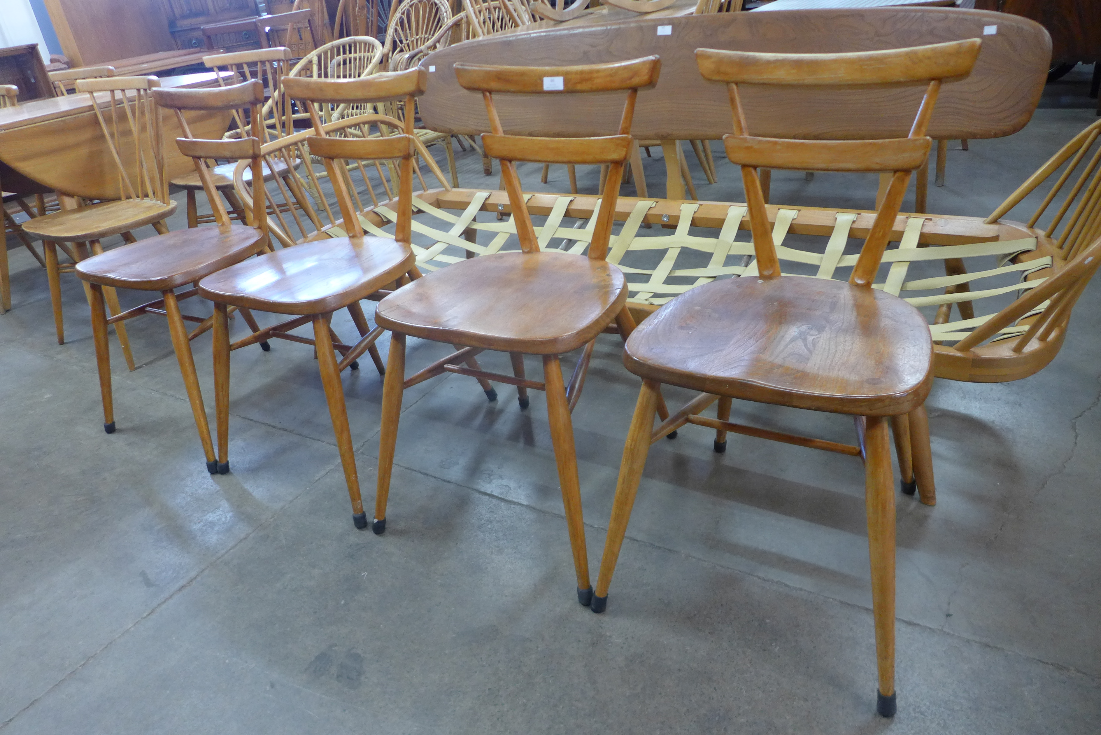 A set of four Ercol green dot beech stacking chairs