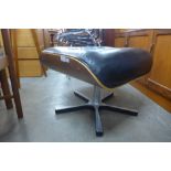 A Charles & Ray Eames style black leather, rosewood effect and chrome footstool