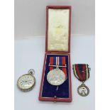 A WWII medal, a Military Nursing Service Reserve medal and a silver fob watch