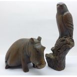 A carved wooden hippopotamus and a resin hawk