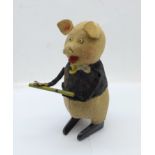 A Schuco clockwork flute playing pig toy, made in Germany