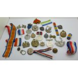 A collection of military badges, medallions, medal ribbons, etc.