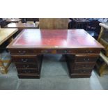 A mahogany and red leather topped library desk