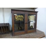 A Victorian mahogany two door counter top shop cabinet, bearing later Cadbury's inscription to doors