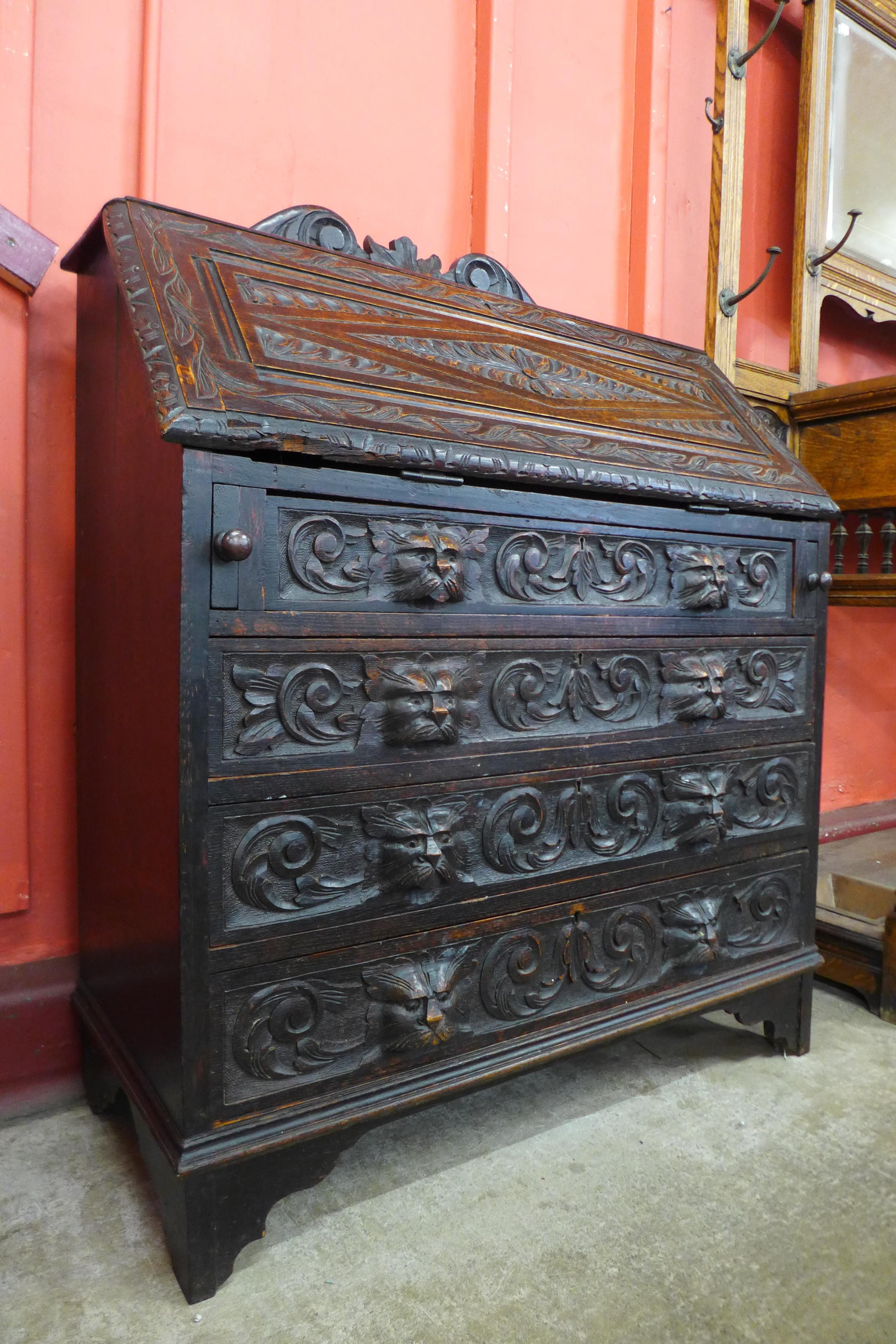 A Victorian Jacobean Revival carved oak bureau