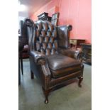 A mahogany and brown leather wingback armchair