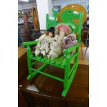 A painted child's rocking chair and three dolls