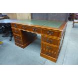 A yew wood and green leather topped pedestal desk