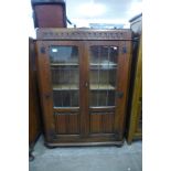 A carved oak linenfold two door bookcase