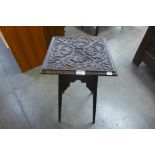 An Arts and Crafts carved oak occasional table