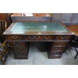 A mahogany and green leather topped pedestal desk