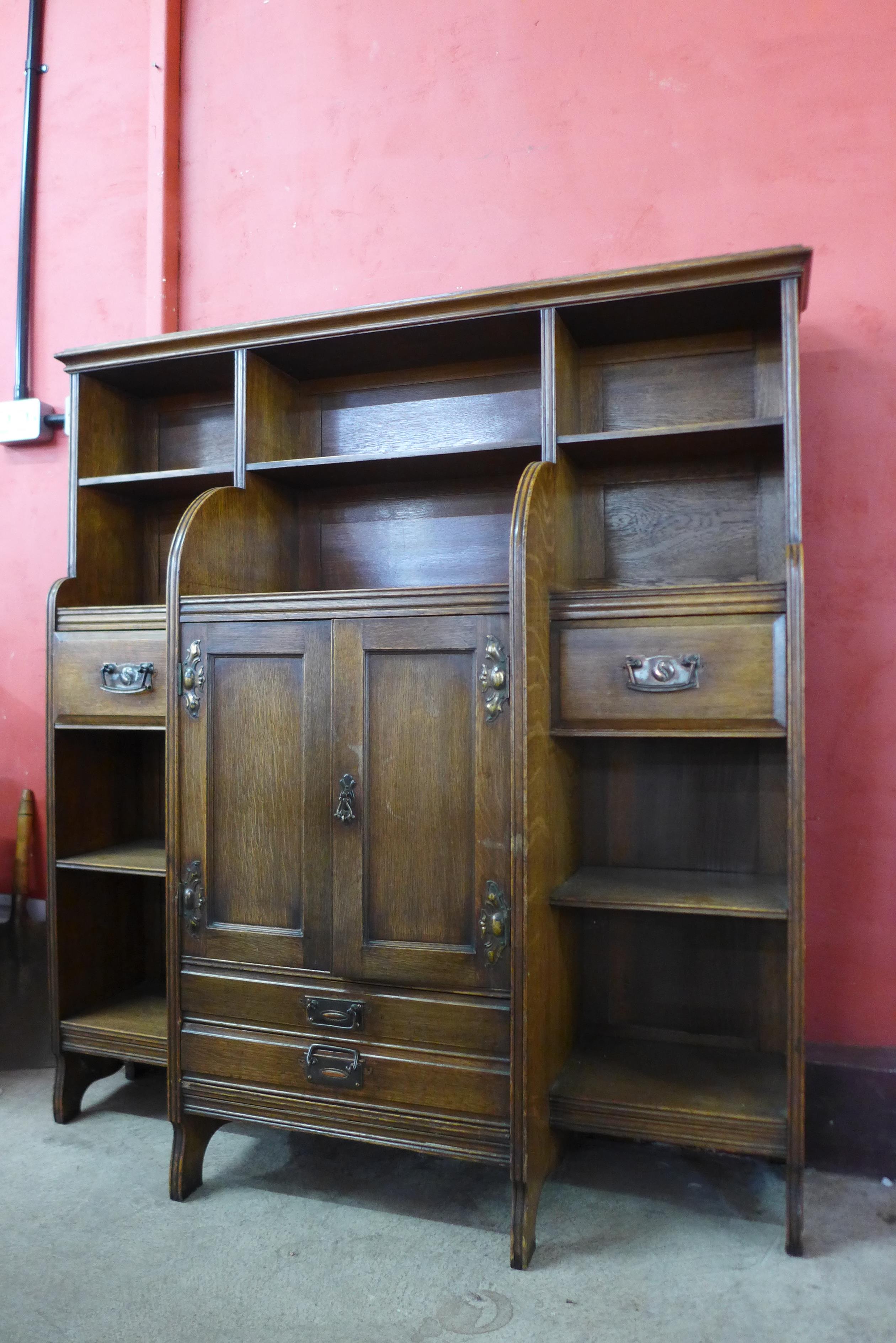 An Arts and Crafts oak open breakfront bookcase