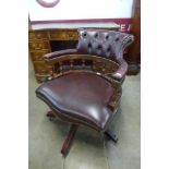 A mahogany and burgundy leather revolving desk chair