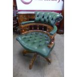 A mahogany and green leather revolving desk chair