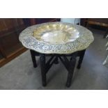 An eastern carved hardwood and brass topped table