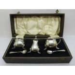 A silver three piece condiment set, Birmingham 1913, 129g, cased