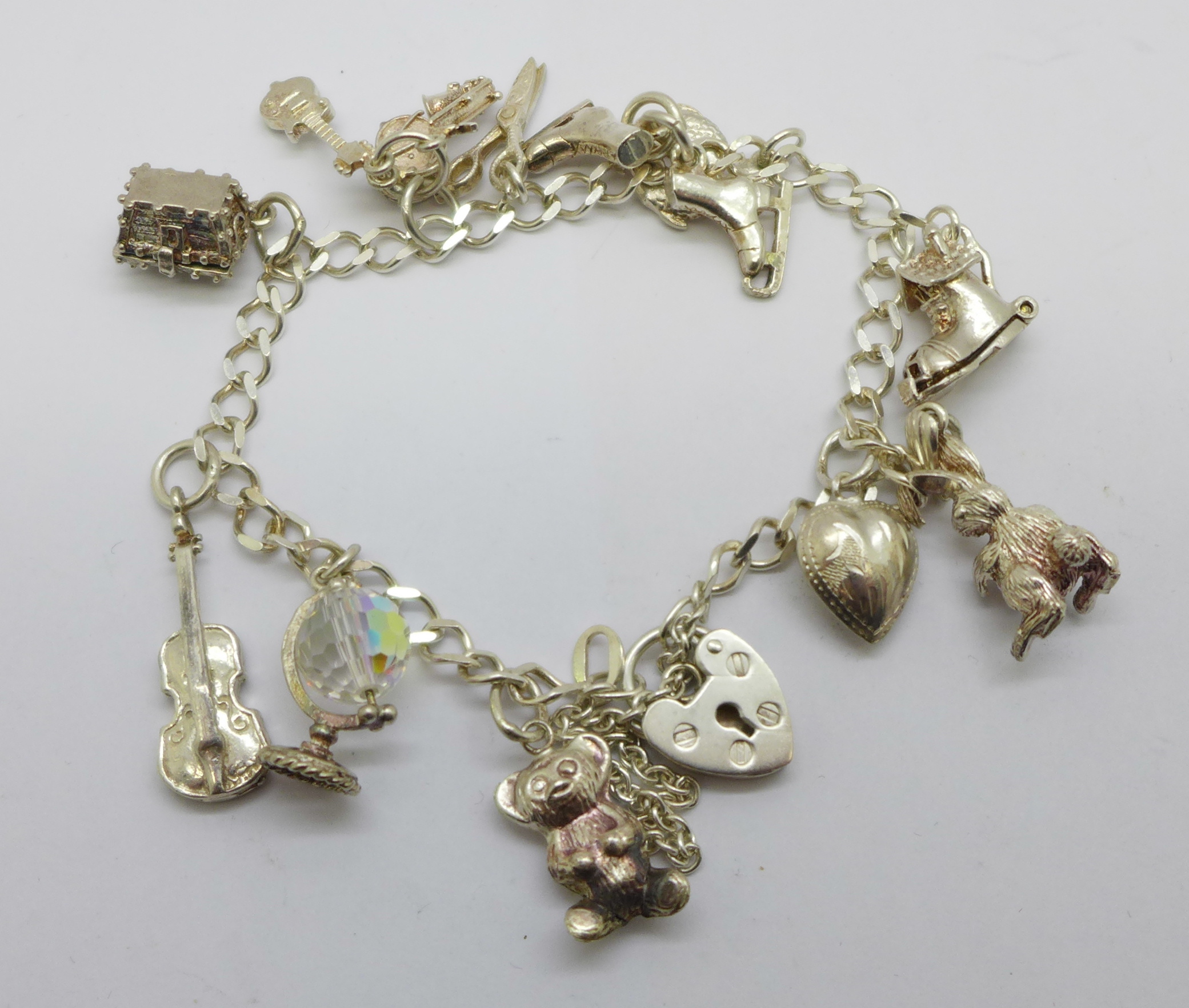 A silver charm bracelet with eleven charms, 19g