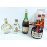 A bottle of Grand Marnier and a bottle of Remy Martin, and two empty bottles